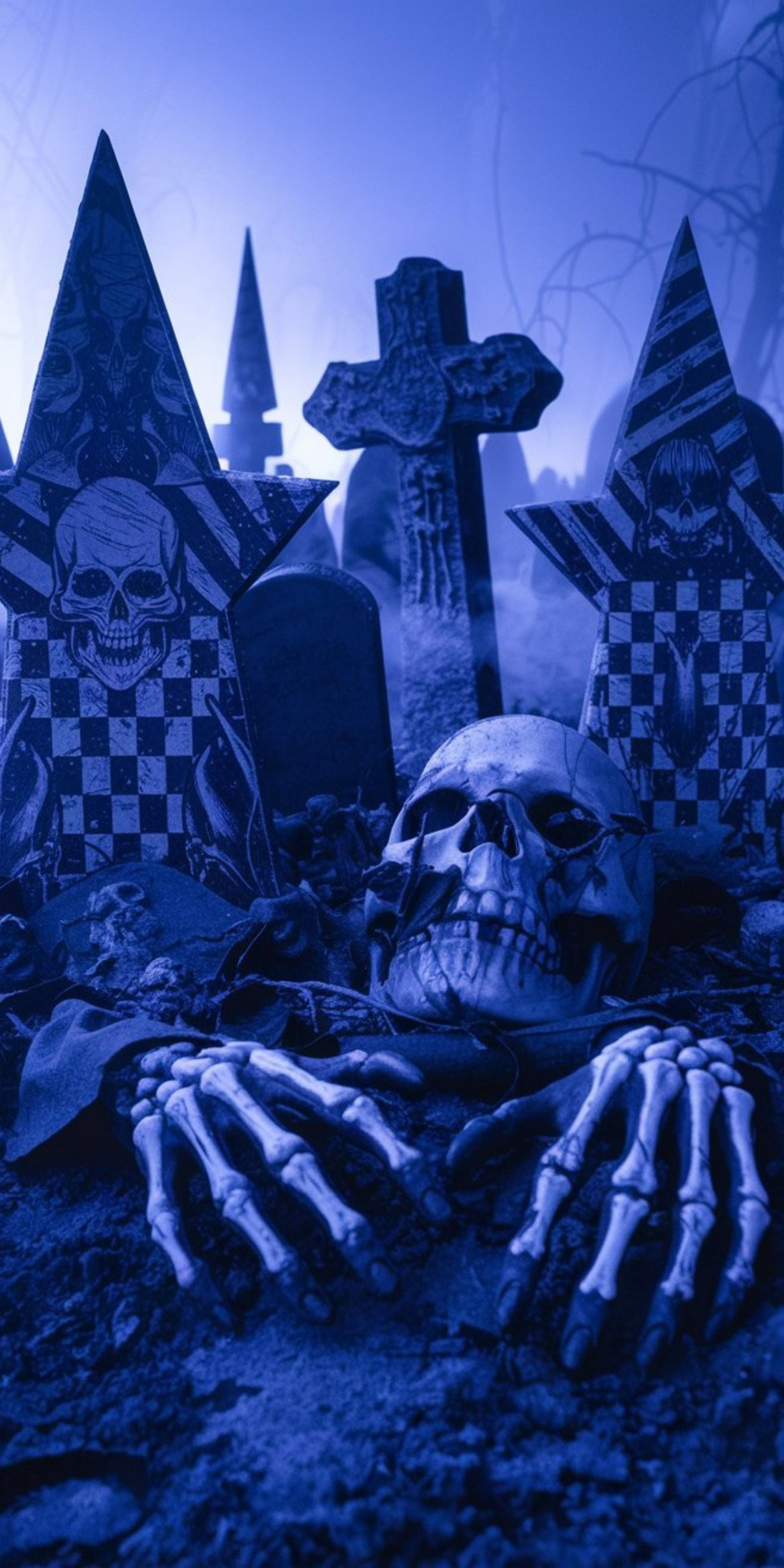 107+ Free Halloween Wallpapers To Download 69 A dark, eerie graveyard scene features tombstones, skulls, skeleton hands, and mist under a blue light, evoking a gothic, haunting atmosphere.